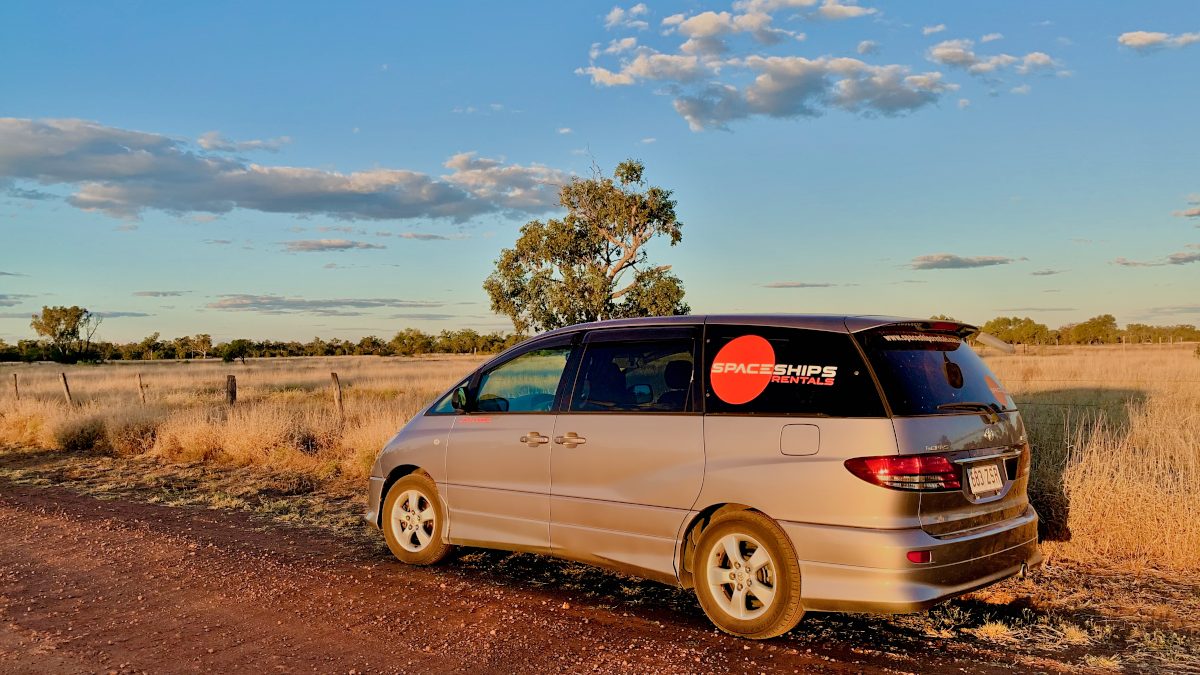 Spaceships campervan on side of the road, while sun is setting behind it