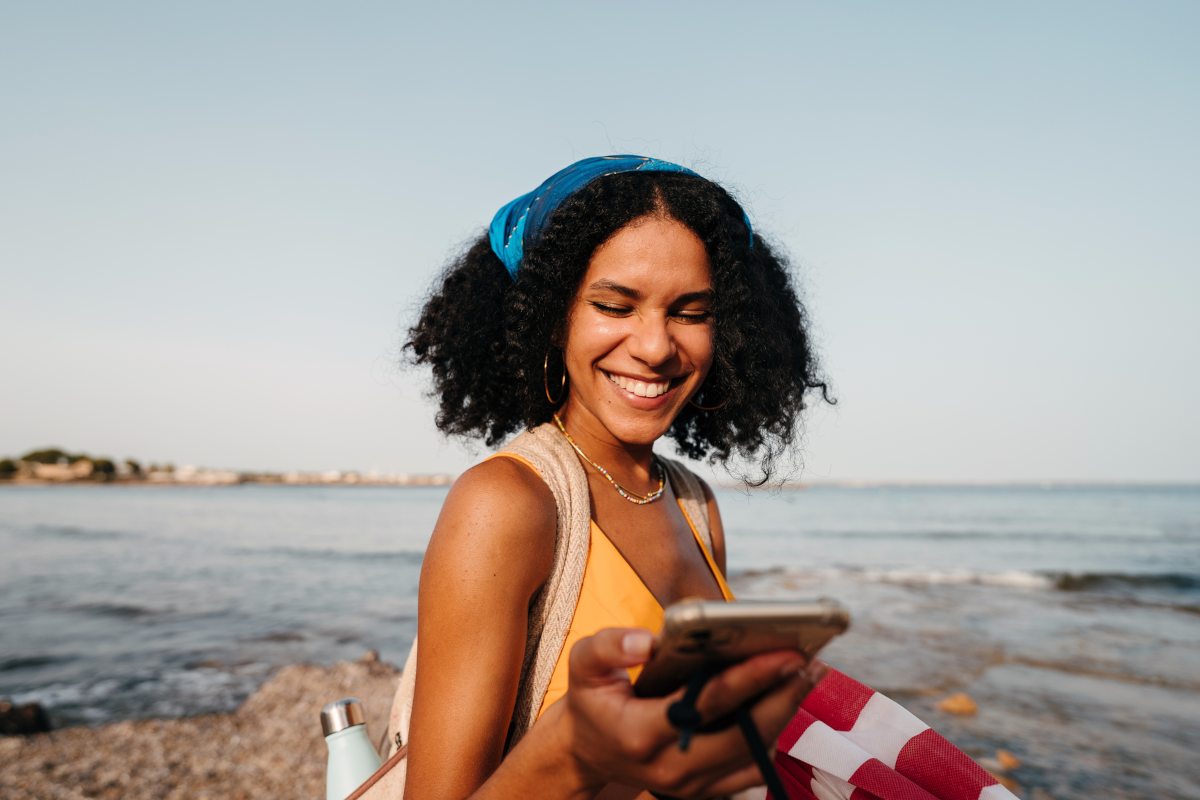 Traveller that is happy they connected to mobile data via an eSIM - coastal setting with ocean in the background